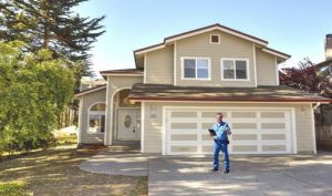 Picture of a home inspector by a new home
